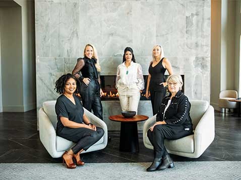 A group of professionally dressed women posing for a photo together