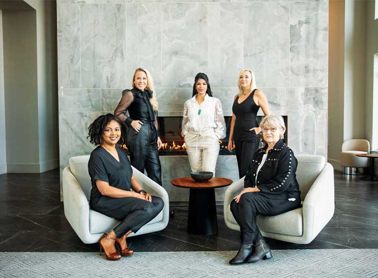 A group of professionally dressed women posing for a photo together